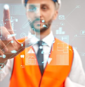 Close up of architect wearing reflective vest and helmet. Selective focus of digital tactile charts screen, man touching virtual icon on projection. Concept of digitalization, construction.